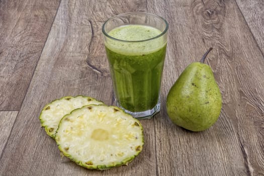 Blended fruit smoothie with ingredients on wooden table