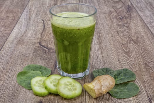 Blended fruit smoothie with ingredients on wooden table