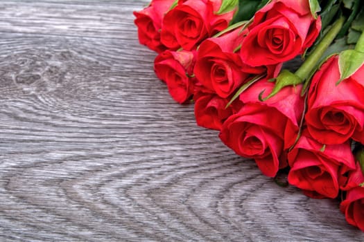 Red roses on a grey wooden background