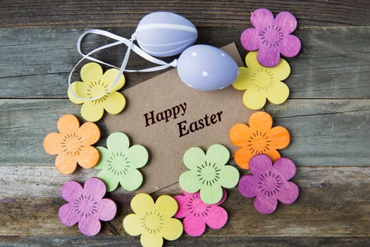 Happy Easter greeting card surrounded by Easter eggs and flowers.