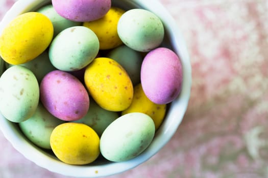 Milk chocolate easter eggs in cup seen from directly above.