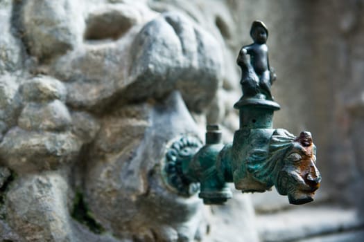 Lion shaped bronze tap at cloisters of Holy Cross and Saint Eulalia, Barcelona, Spain