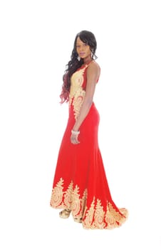 A gorgeous African American woman standing in a long red evening dress.with gold embroideries and long black hair isolated for white background..
