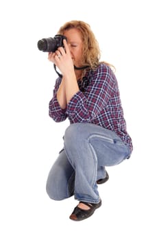A meddle age women crouching on the floor and taking pictures with a.digital camera, isolated for white background..