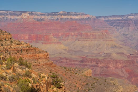 Landscape of the Grand Canyon with desert rock in the foreground.