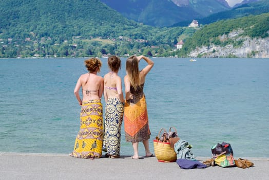 Three young women at the waterfront of lake