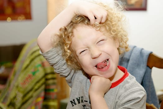 a little blond boy making faces