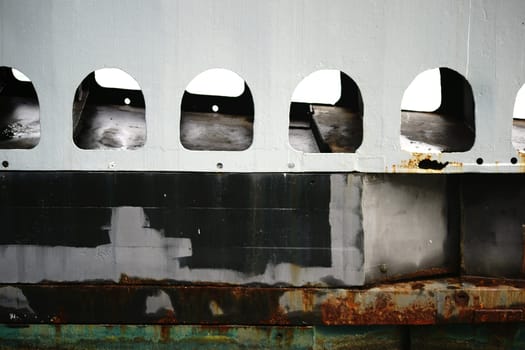 The close-up of a rusty and algae-covered ship wall of an underwater sea boat.