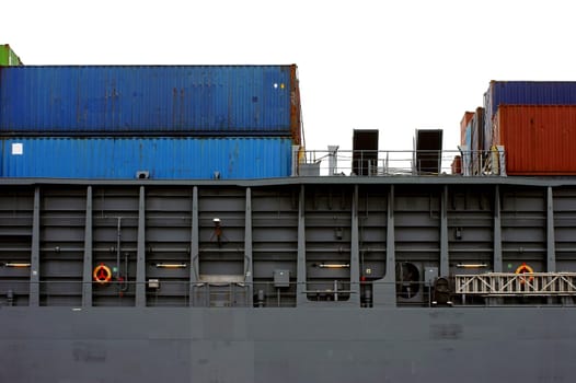 The side view and close-up of the railing and the upper deck of a container ship.