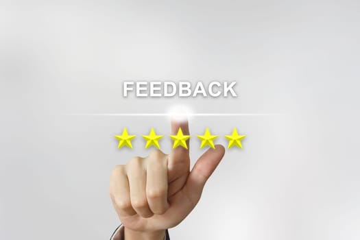 business hand clicking feedback with five stars on screen