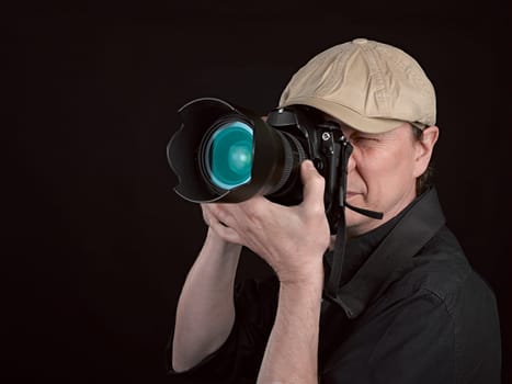 Photographer looking through camera  on black background