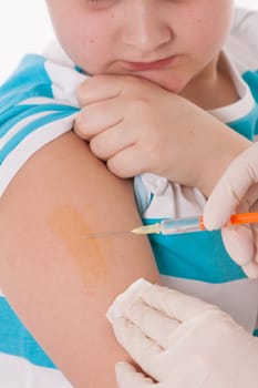 Doctor giving a child injection in arm on isolated image.