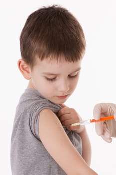 Doctor giving a child injection in arm on isolated image.
