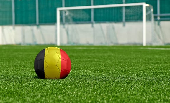 Soccer ball with the flag from Belgium on the green field