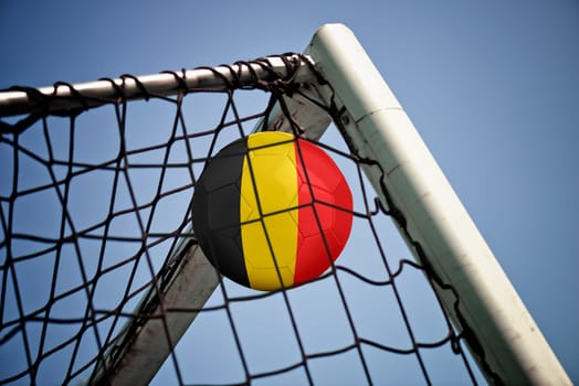 Soccerball in net with the flag of Belgium ready for championship