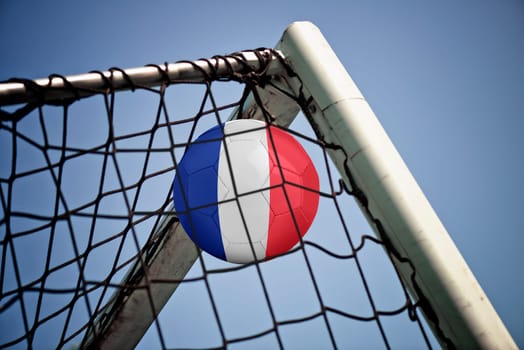 Soccerball in net with the flag of France ready for championship
