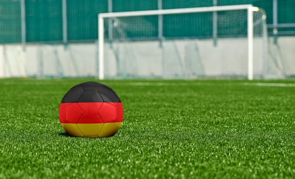 Soccer ball with the flag from Germany on the green field