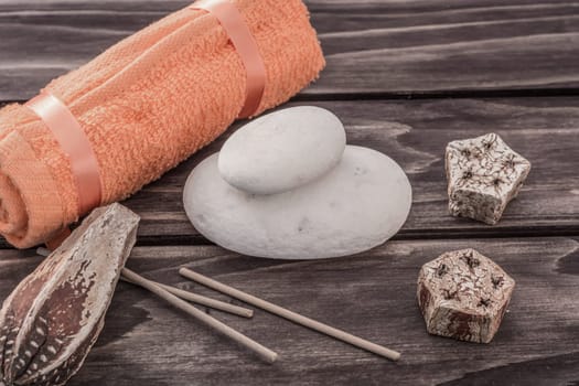 Spa concept with towel stones and aroma elements on wooden board