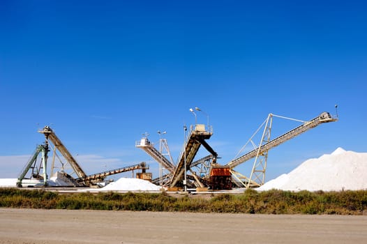 Site operating company saline Aigues-Mortes in the Camargue where stackers stack hills of sea salt.