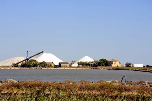 Site operating sea salt saline Aigues-Mortes with big machines and trucks working for the salt storage