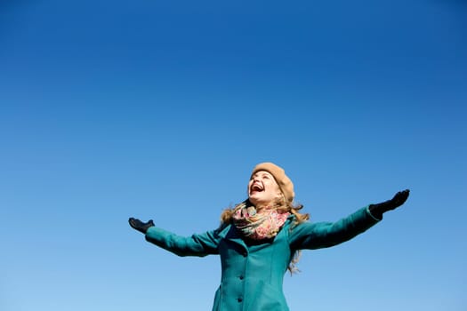 blond casual woman happy outdoors with blue sky