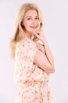 blond woman wearing beige dress on white background