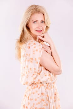 blond woman wearing beige dress on white background