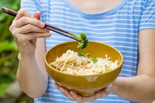 woman hand holding a bowl of noodles