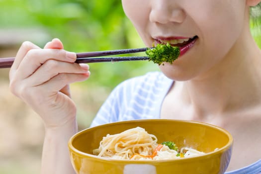 women hand using chopstick eat Broccoli