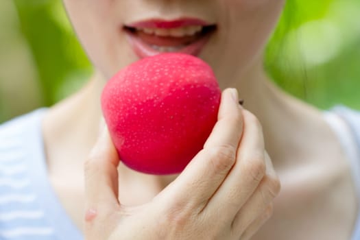 close up women eating red apple