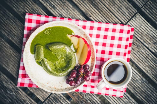 Green tea cake with friut in palte on wooden