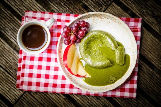 Green tea cake with friut in palte on wooden
