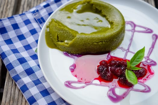 Green tea cake with friut in palte on wooden