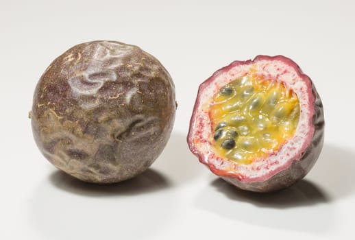 Passion Fruit Cross Section Close up. One uncut and whone sliced in half.