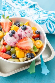 Colourful fruit salad made from fresh fruit and two scoops of ice cream