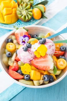 Colourful fruit salad made from fresh fruit and two scoops of ice cream
