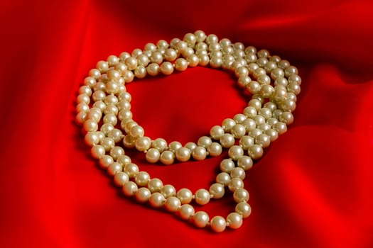 Pearl necklace on a red silk