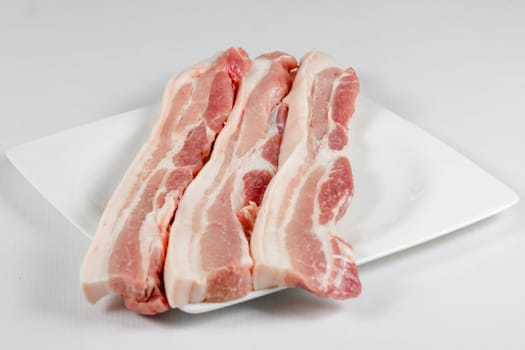 streaky pork in plate on white background