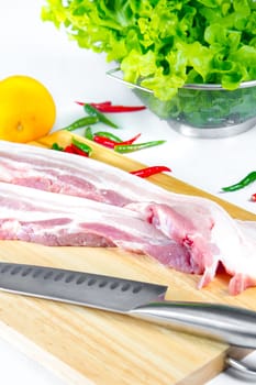 streaky pork with knife on wooden boards