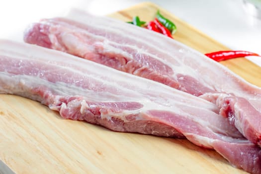 streaky pork with knife on wooden boards