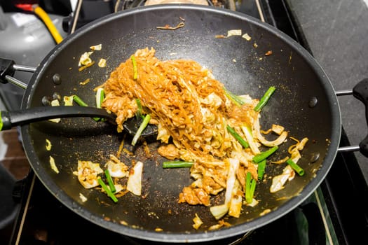 chef making fried noodle in pan for thai food menu