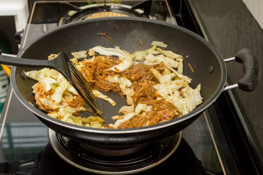 chef making fried noodle in pan for thai food menu
