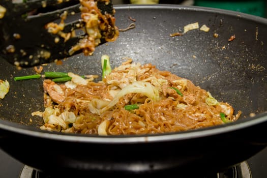 chef making fried noodle in pan for thai food menu