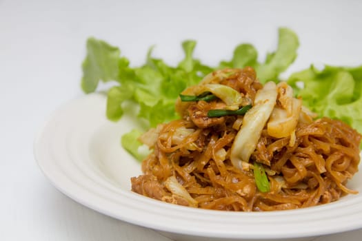 chef making fried noodle in white plate