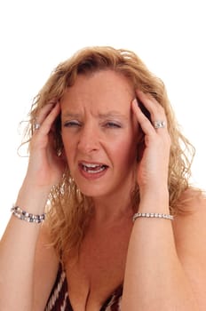 A blond woman suffering from headache is a closeup image, holding her.hands on her head, isolated for white background..