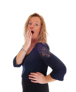 A pretty blond woman holding her hand before her mouth, looking.shocked and surprised, isolated for white background..
