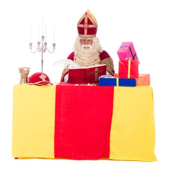 Sinterklaas is working at his desk, at a white background