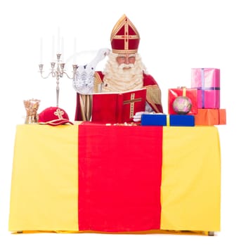 Sinterklaas is working at his desk, at a white background