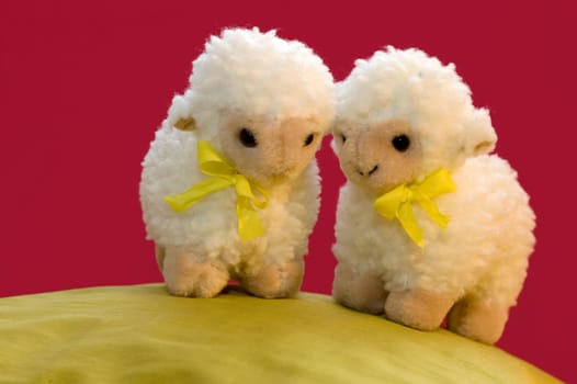 a cute spring picture of two toy sheep on a green hill.