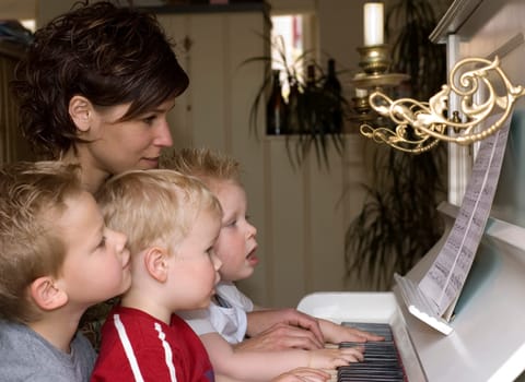 A cute family picture were four people are playing the piano
